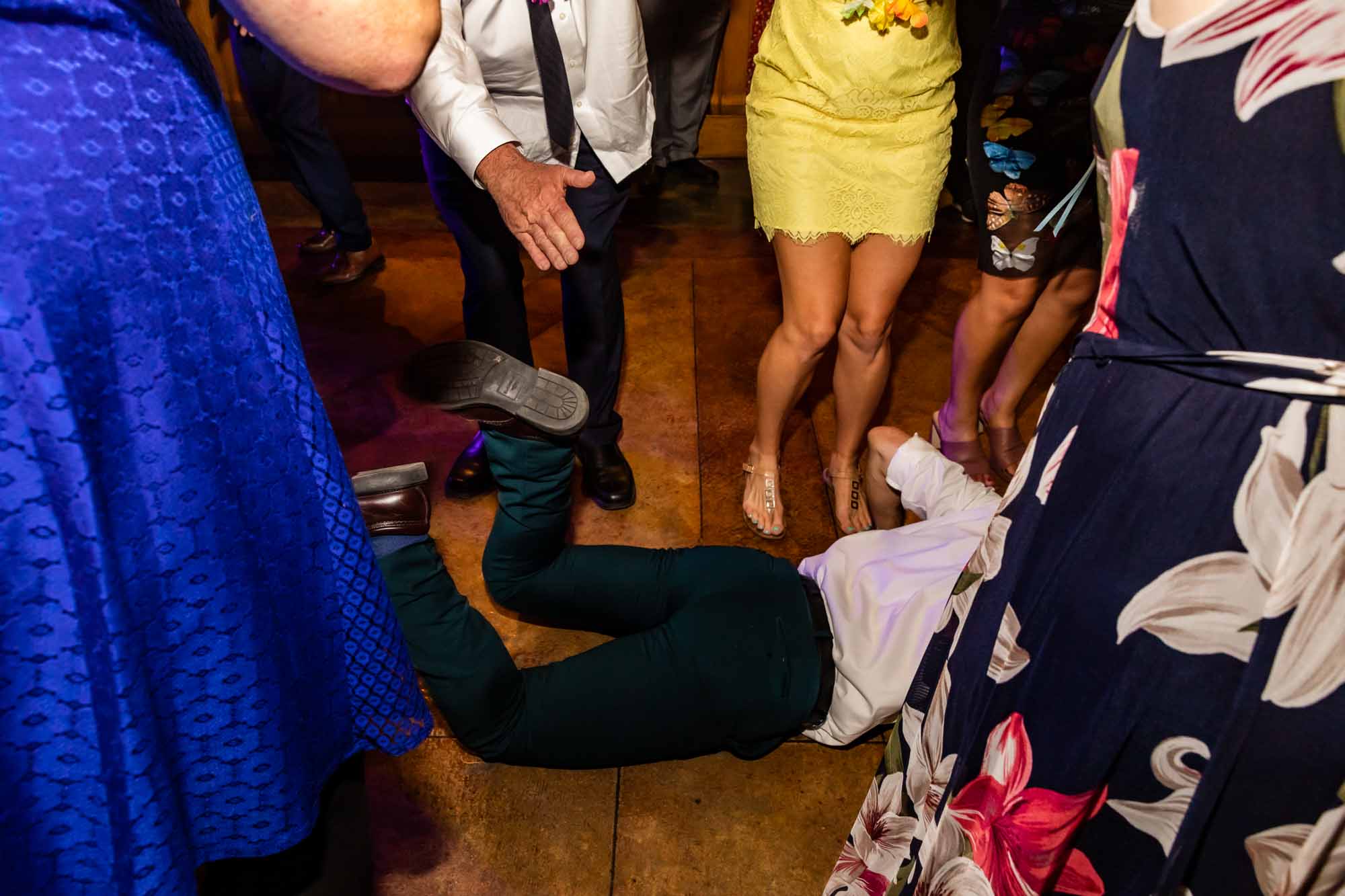 this wedding guest is doing the worm but surrounded by people, and what a creative way to capture this moment by photojournalist wedding photographer, Pamela Anticole